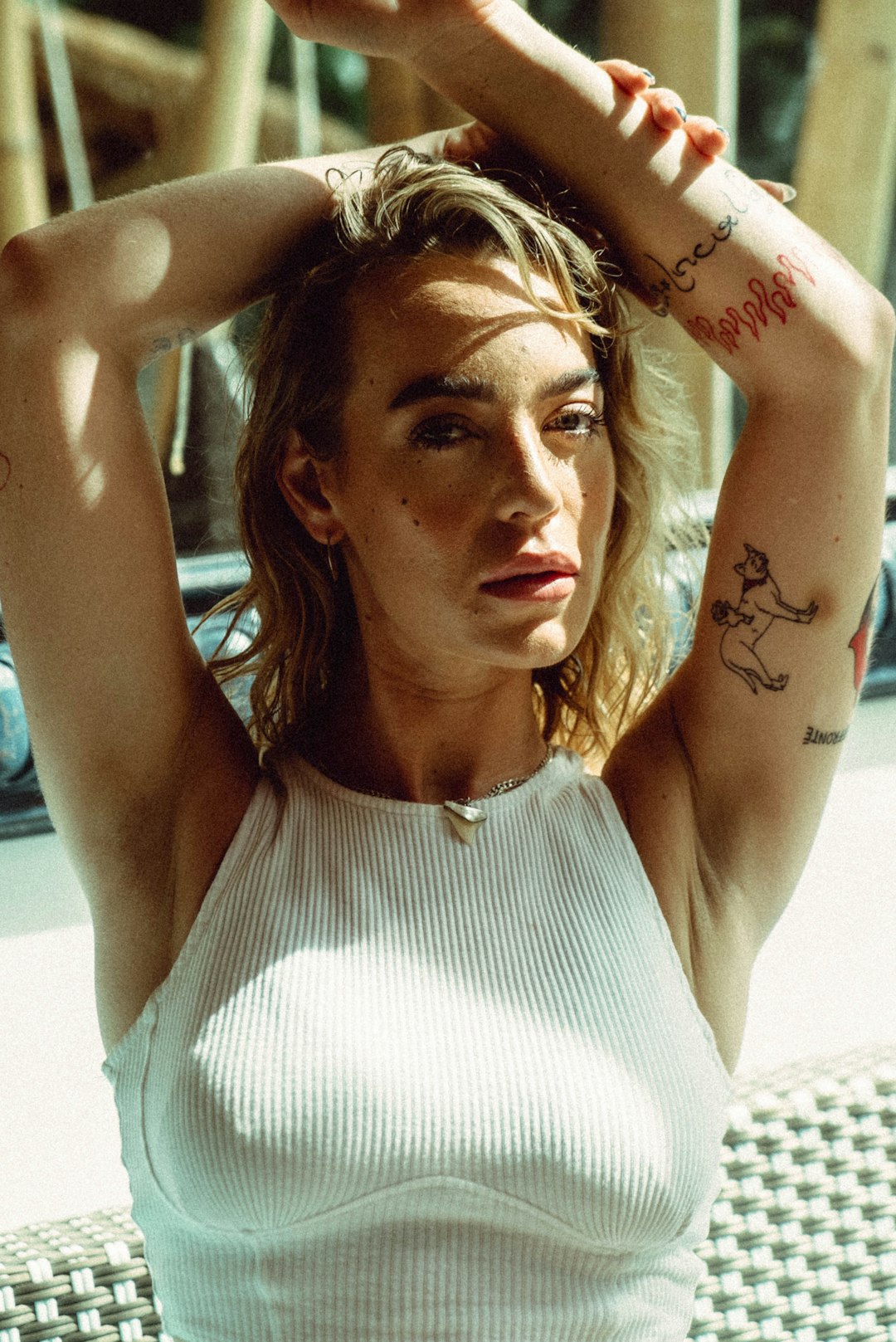 a woman sitting on a bench with her hands behind her head