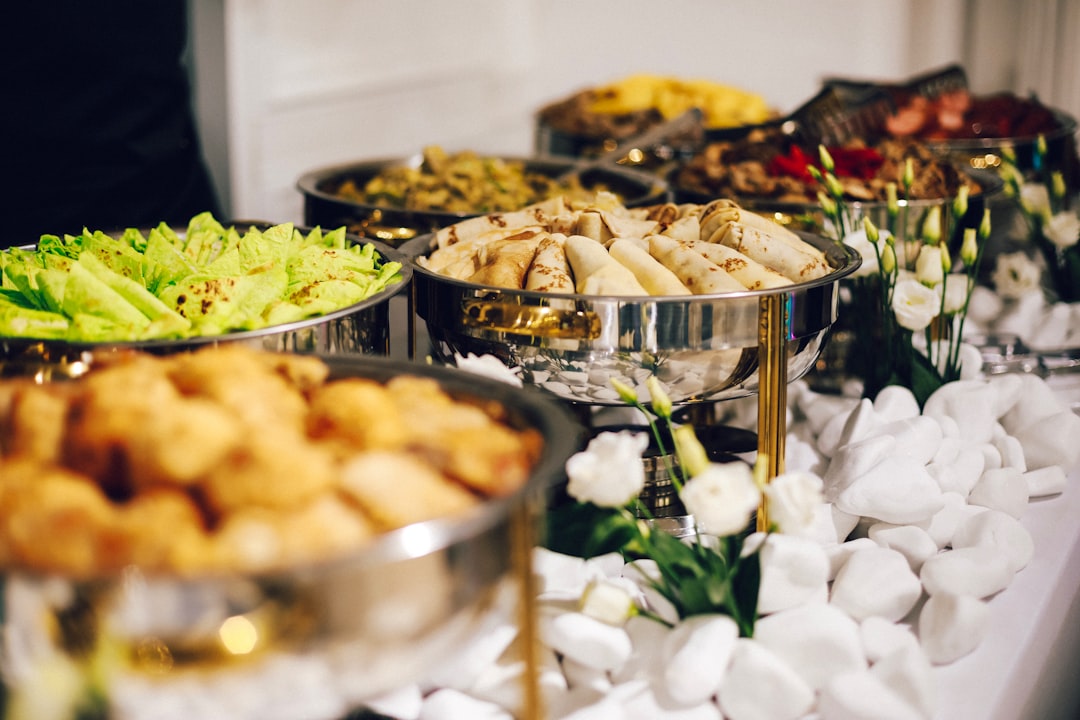 A buffet table with silver chafing dishes filled with various prepared foods