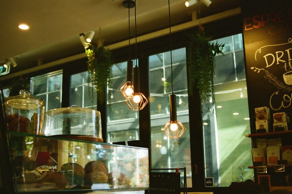 Interior of a cafe with hanging lights and pastries